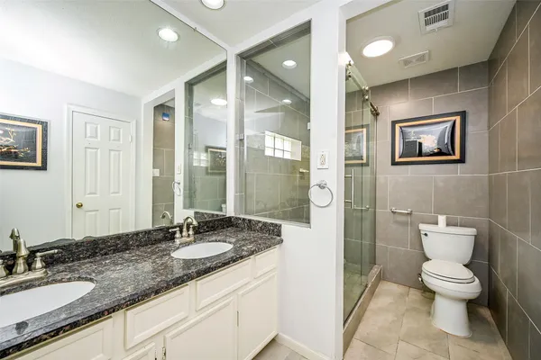 a bathroom with a granite countertop sink toilet and shower