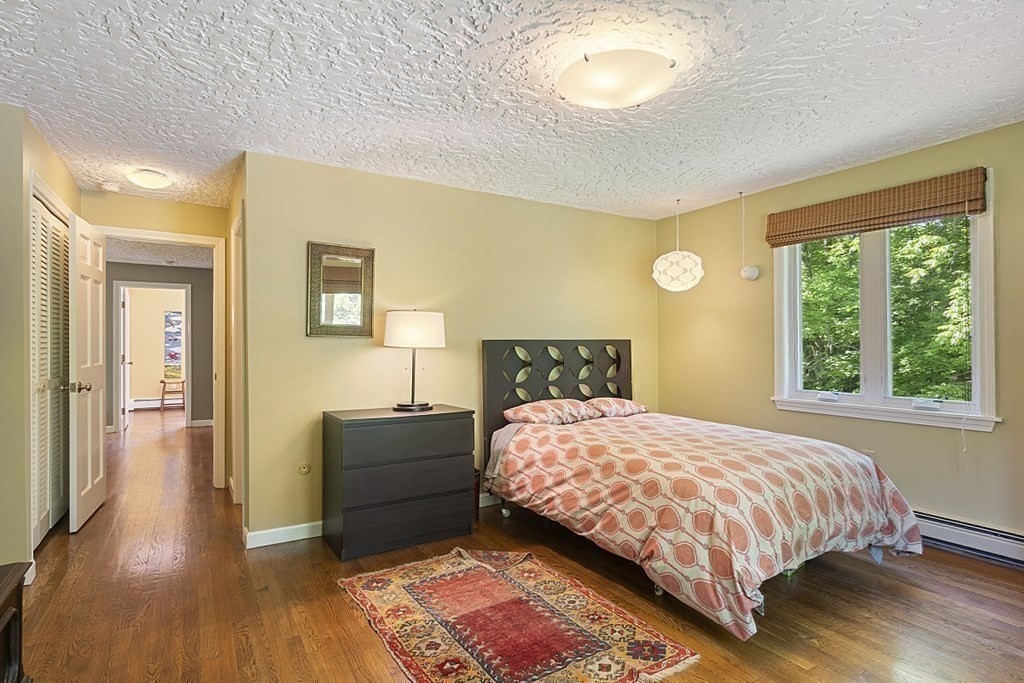 208 Concord Road Lincoln, MA 01773 - Photo 13 of 23 a bedroom with a bed and wooden floor