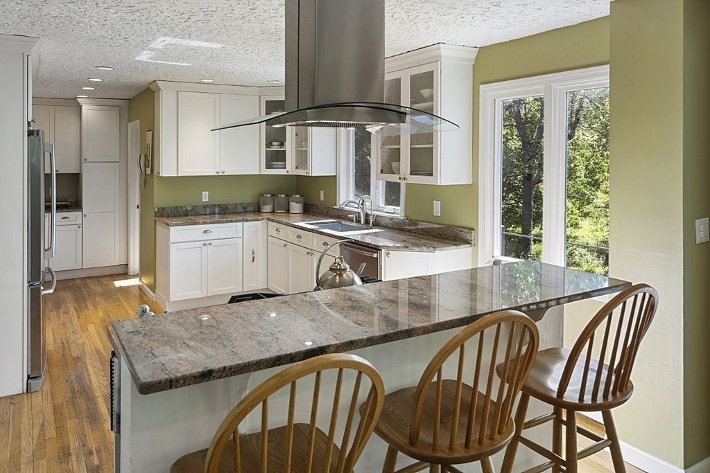 208 Concord Road Lincoln, MA 01773 - Photo 4 of 23 a kitchen with a table chairs sink and cabinets
