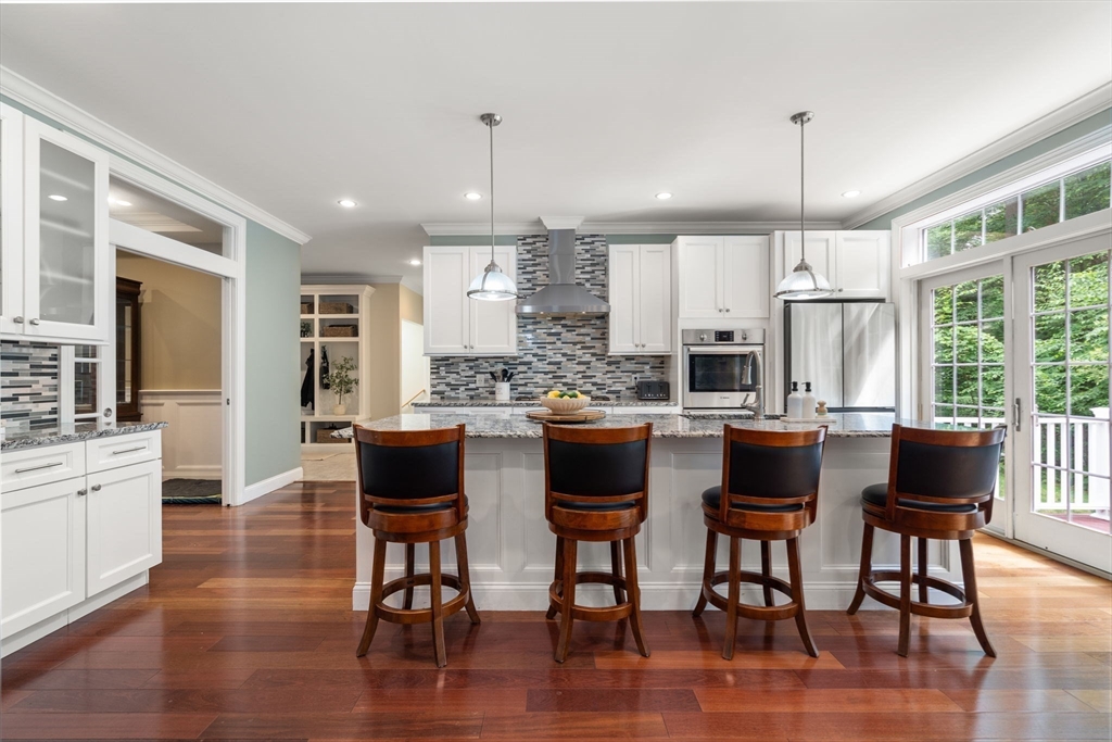 24 Wayside Inn Road Framingham, MA 01701 - Photo 11 of 38 a kitchen with stainless steel appliances granite countertop wooden floor granite top island and chairs