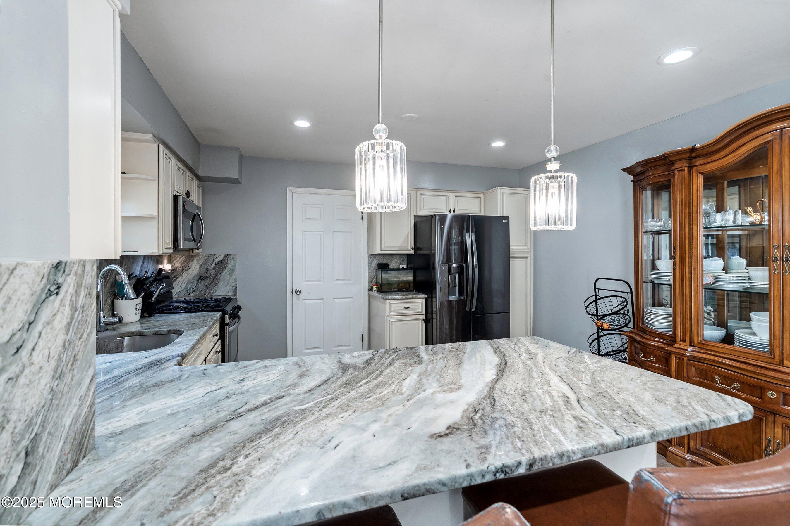 300 Bellanca Road Brick, NJ 08723 - Photo 6 of 23 a kitchen with stainless steel appliances kitchen island granite countertop a sink refrigerator and cabinets