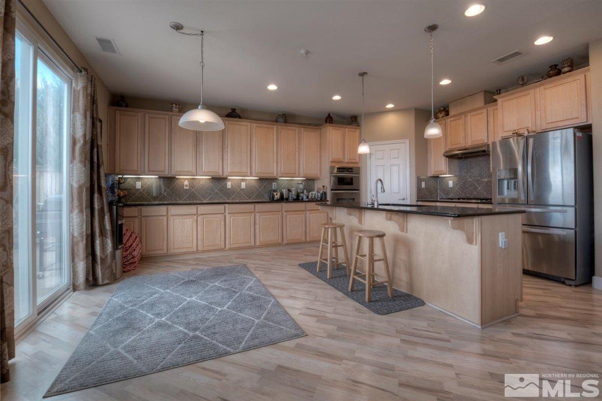 425 Manciano Way Reno, NV 89521 - Photo 5 of 28 a kitchen with stainless steel appliances granite countertop a refrigerator and a sink