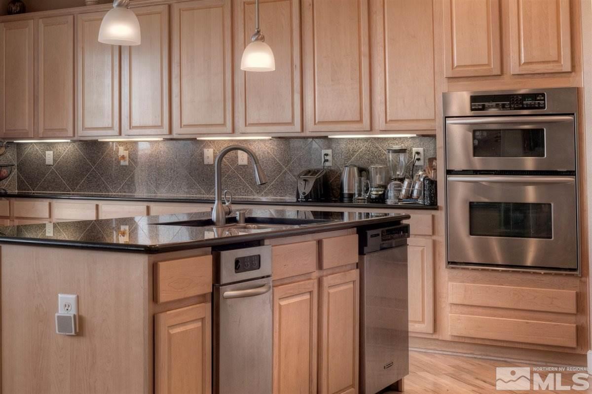 425 Manciano Way Reno, NV 89521 - Photo 7 of 28 a kitchen with granite countertop a sink and cabinets