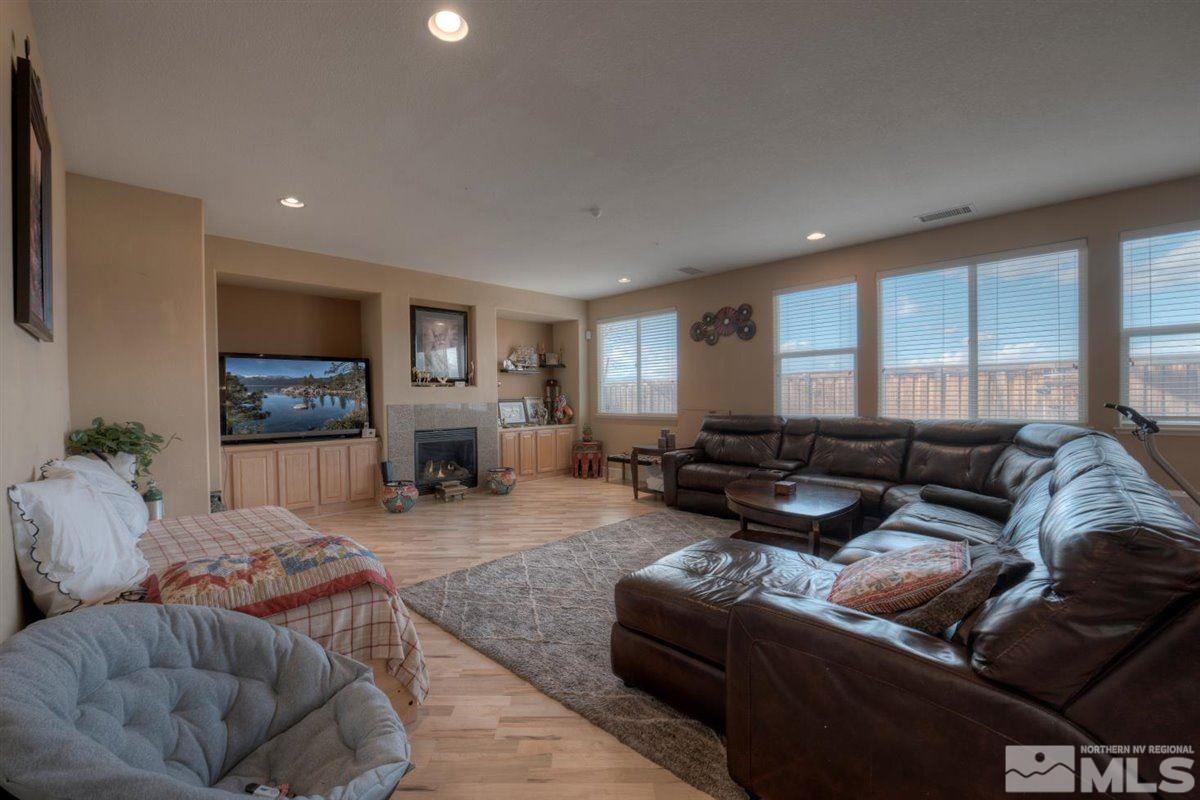 425 Manciano Way Reno, NV 89521 - Photo 9 of 28 a living room with furniture a flat screen tv and a fireplace