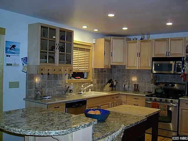 21885 Adobe Road Reno, NV 89521 - Photo 4 of 9 a kitchen with granite countertop a stove a sink and a microwave