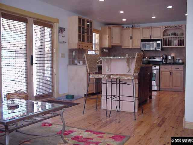 21885 Adobe Road Reno, NV 89521 - Photo 5 of 9 a kitchen with stainless steel appliances granite countertop a stove a sink dishwasher and a refrigerator with wooden floor