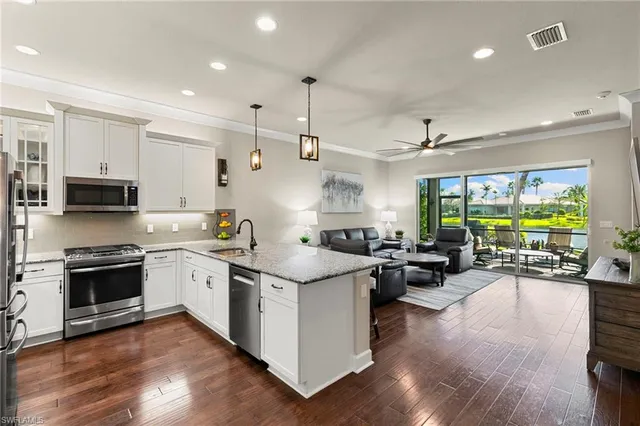 a kitchen with stainless steel appliances granite countertop a lot of counter space and wooden floors