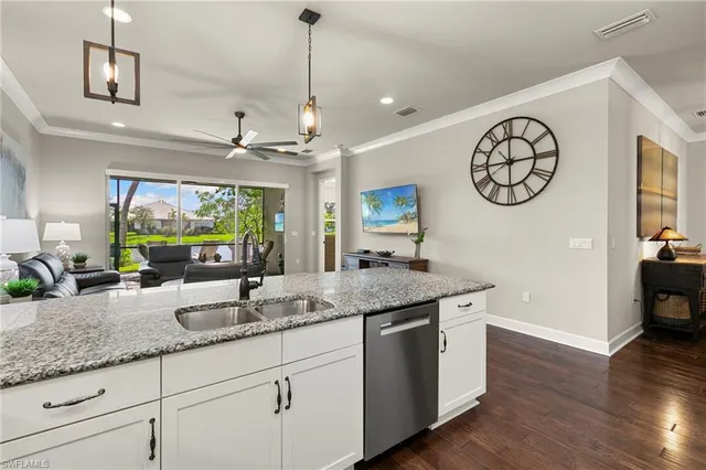 a kitchen with kitchen island granite countertop a sink a stove and a wooden floors