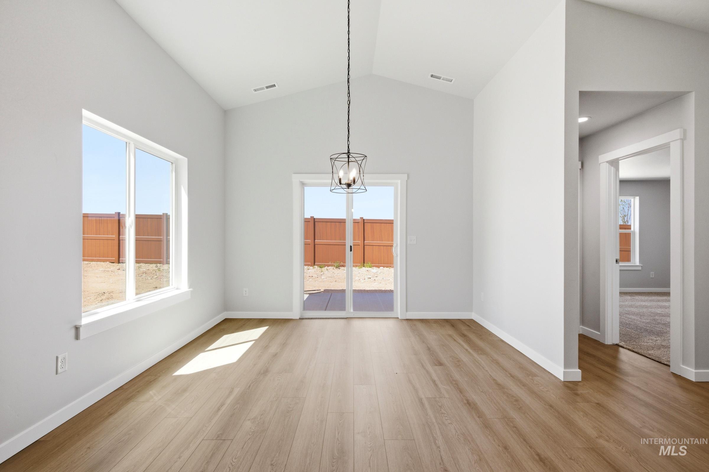 1184 West Jasper Street Meridian, ID 83642 - Photo 7 of 18 Vaulted ceiling room featuring wood-finish flooring, a large picture window, and sliding glass doors to the exterior