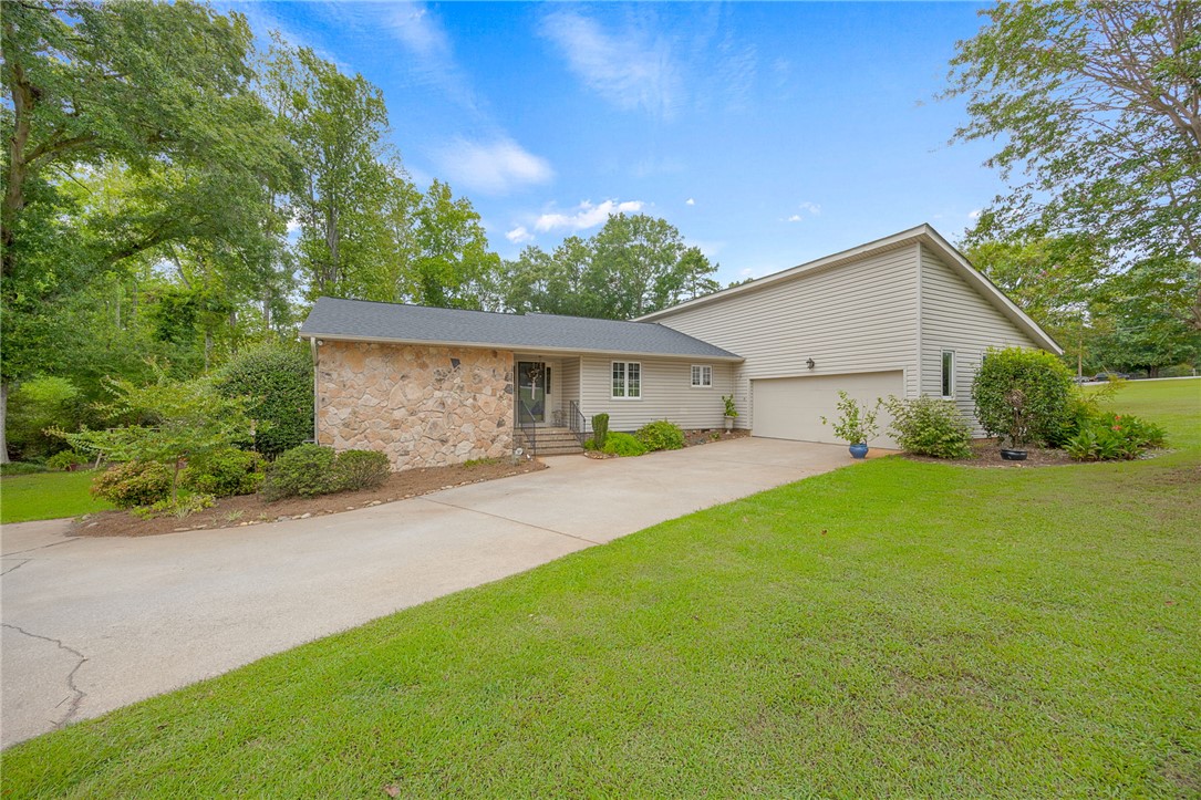 131 Bowen Road Anderson, SC 29621 - Photo 1 of 36 An inviting stone facade pairs beautifully with natural siding along the concrete driveway.
