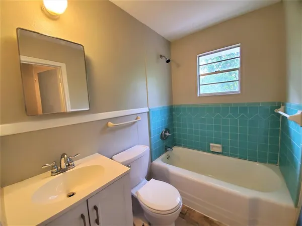 a bathroom with a sink mirror toilet and bathtub