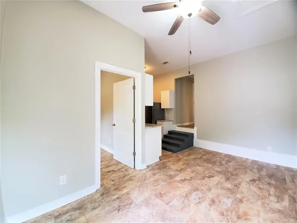 a view of a room with a stylish ceiling fan and entryway