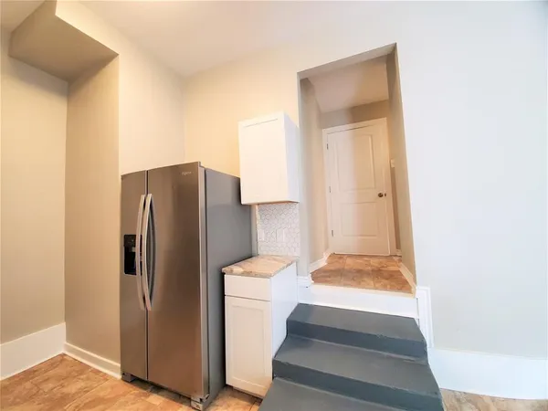 a view of a kitchen with refrigerator and mirror