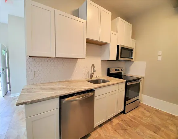 a kitchen with stainless steel appliances granite countertop a sink stove and microwave
