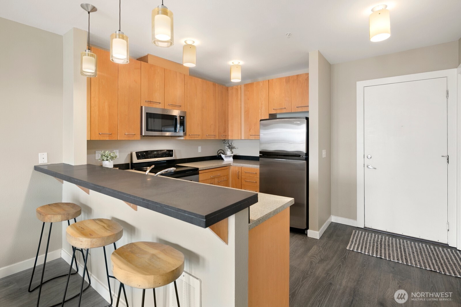 655 Crockett Street, Unit A204 Seattle, WA 98109 - Photo 12 of 23 a kitchen with kitchen island a counter space a sink appliances and cabinets