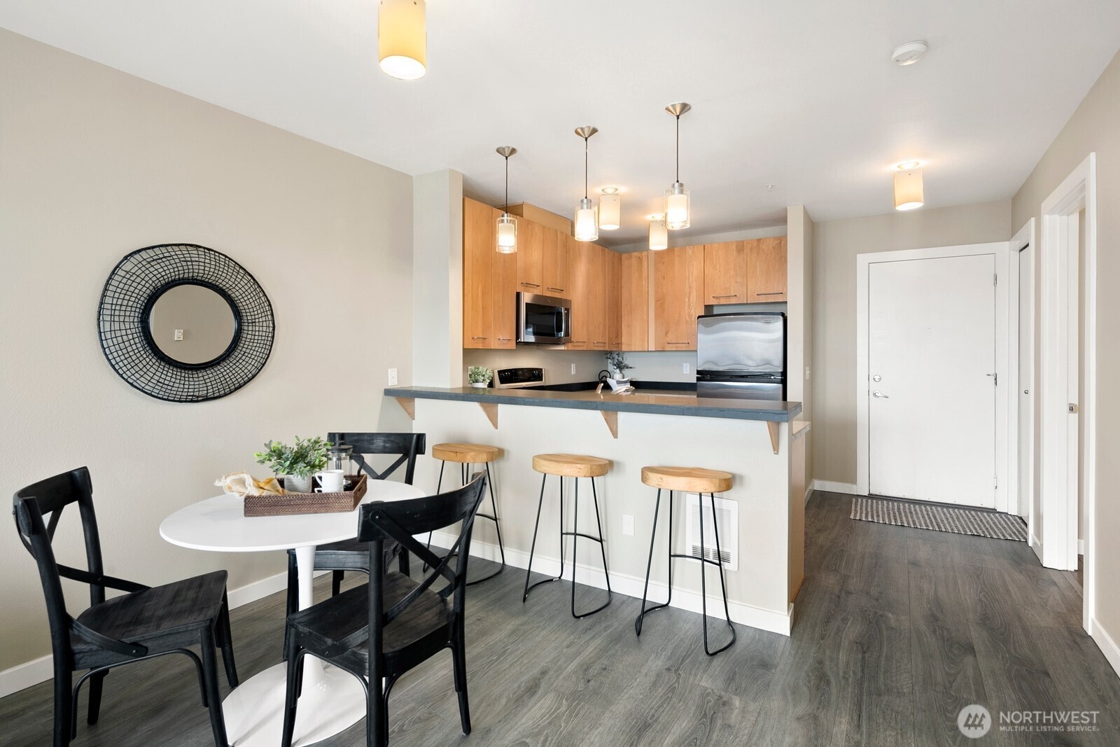 655 Crockett Street, Unit A204 Seattle, WA 98109 - Photo 14 of 23 a kitchen with stainless steel appliances granite countertop a stove top oven a sink dishwasher a dining table and chairs with wooden floor