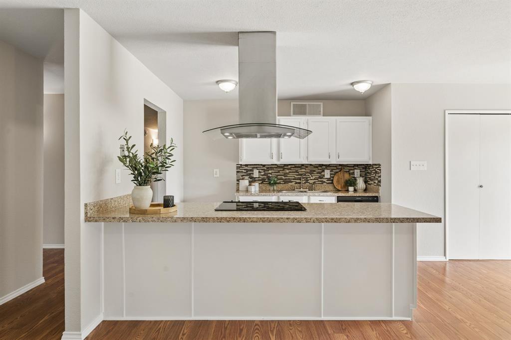5620 Perrin Street The Colony, TX 75056 - Photo 7 of 31 a kitchen with stainless steel appliances granite countertop a sink a stove and white cabinets