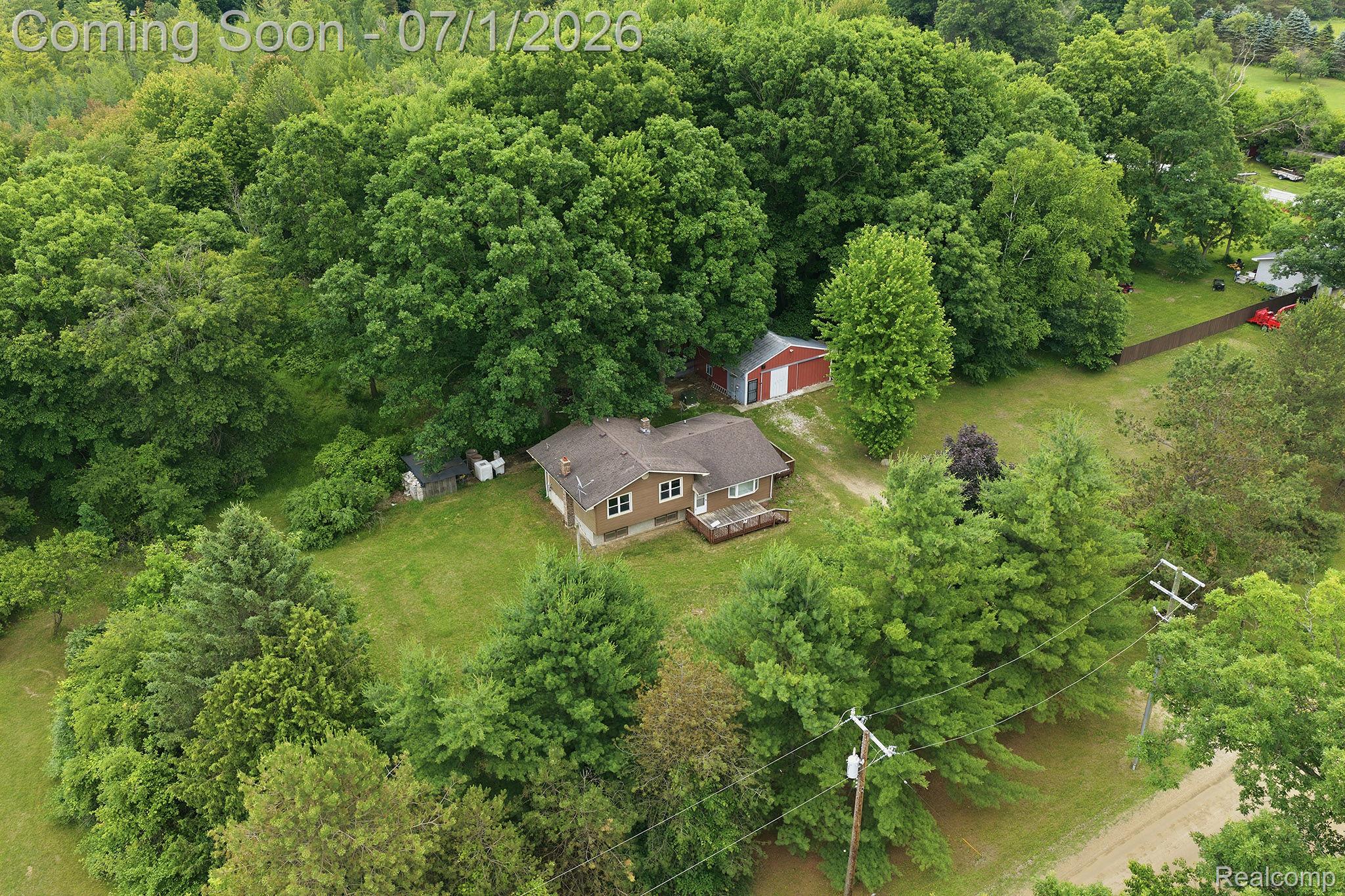 4762 Lonsberry Road Columbiaville, MI 48421 - Photo 30 of 36 Ranch-style dwelling with a shingle roof and a deck, surrounded by mature trees