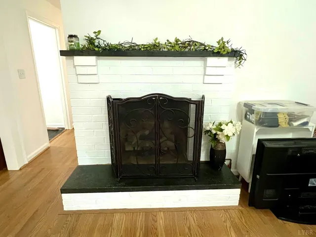 a view of empty room with wooden floor and fireplace