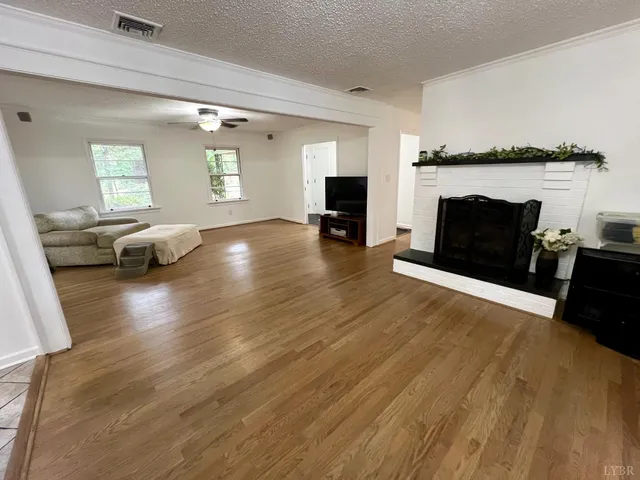 a view of empty room with wooden floor and fireplace