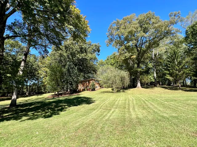 a kitchen with a stove a sink dishwasher a dining table and chairs with wooden floor