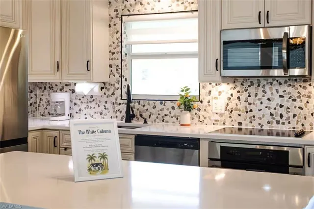 a kitchen with stainless steel appliances kitchen island granite countertop a stove and a sink