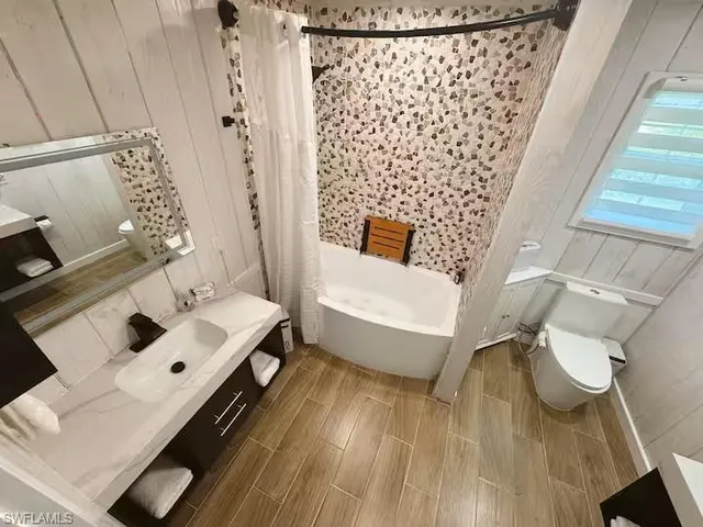 a white bath tub sitting next to a white toilet