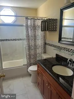 a bathroom with a granite countertop sink mirror vanity and toilet