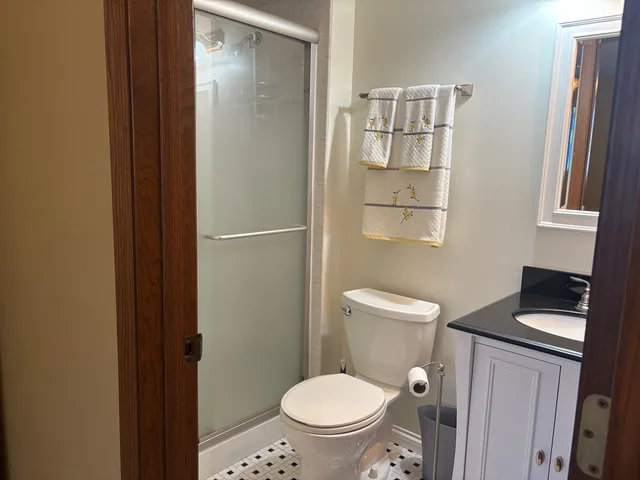 a white toilet sitting next to a bathroom sink and vanity