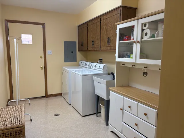 a utility room with cabinets washer and dryer