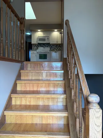 a view of staircase with white walls and a painting on the wall