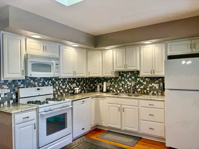 a kitchen with white cabinets and white appliances
