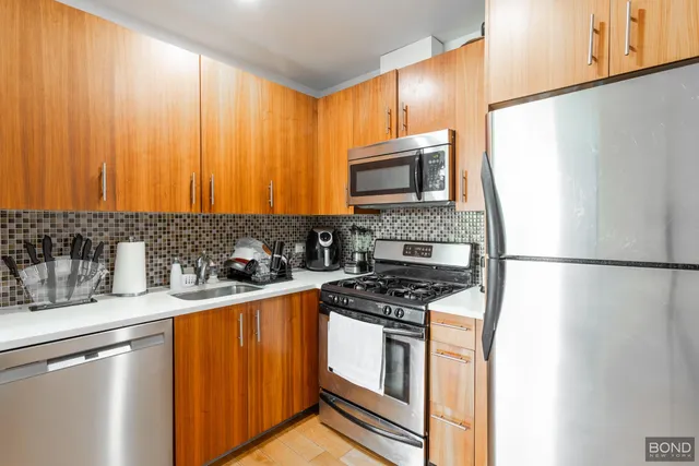 a kitchen with stainless steel appliances granite countertop a refrigerator stove a sink dishwasher and microwave