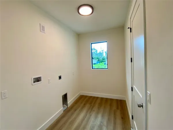 a view of empty room with window and wooden floor
