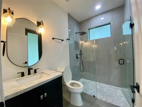 a bathroom with a double vanity sink toilet and shower