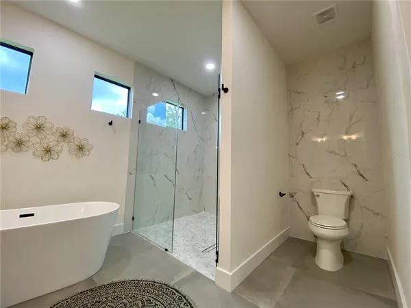 a spacious bathroom with a double vanity sink mirror and bathtub