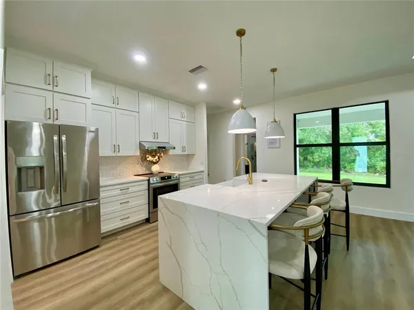 a kitchen with stainless steel appliances granite countertop a refrigerator sink and stove