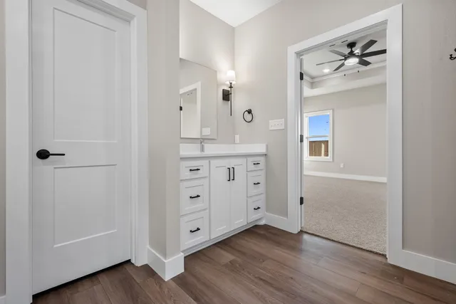 a view of cabinets wooden floors and entryway with white walls