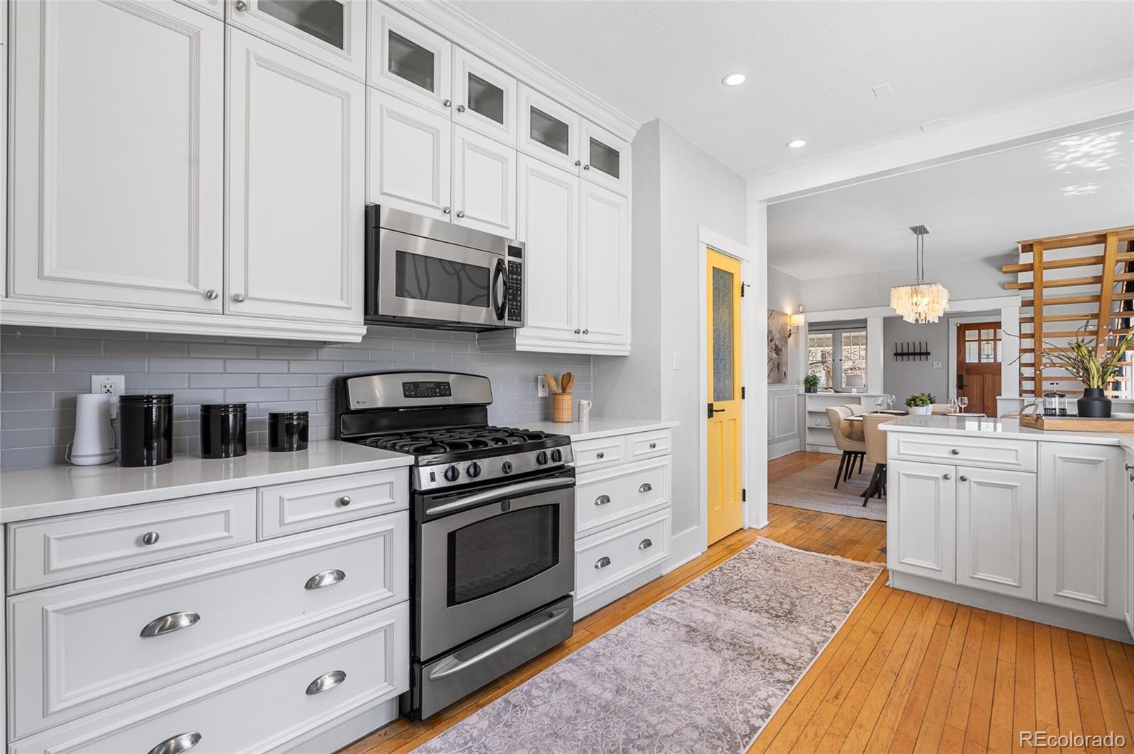 1065 Jackson Street Denver, CO 80206 - Photo 20 of 50 a kitchen with stainless steel appliances granite countertop a stove and a wooden cabinets