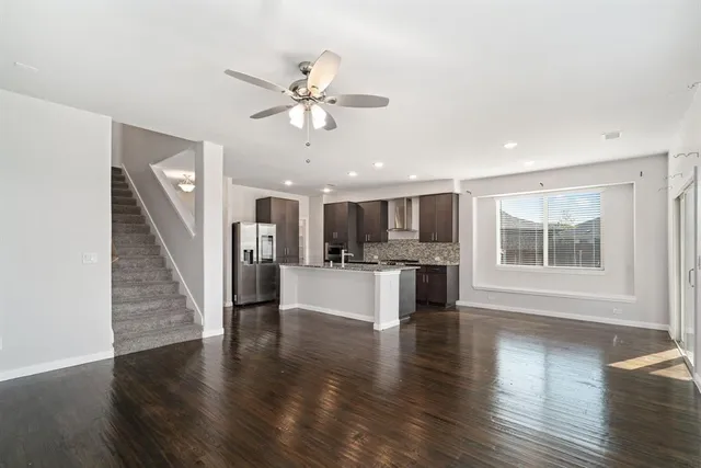 a view of a living room a kitchen with wooden floor and a kitchen