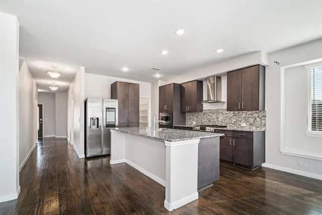a kitchen with stainless steel appliances granite countertop a stove and a refrigerator