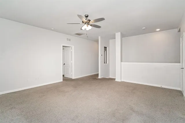 a view of an empty room with a ceiling fan