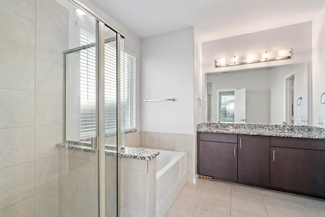 a bathroom with a granite countertop sink a mirror and a bathtub