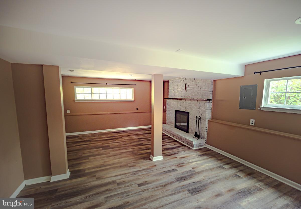 892 Estates Boulevard Hamilton, NJ 08690 - Photo 14 of 36 an empty room with wooden floor fireplace and windows