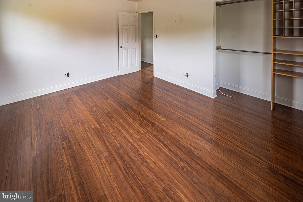 892 Estates Boulevard Hamilton, NJ 08690 - Photo 24 of 36 an empty room with wooden floor and a refrigerator