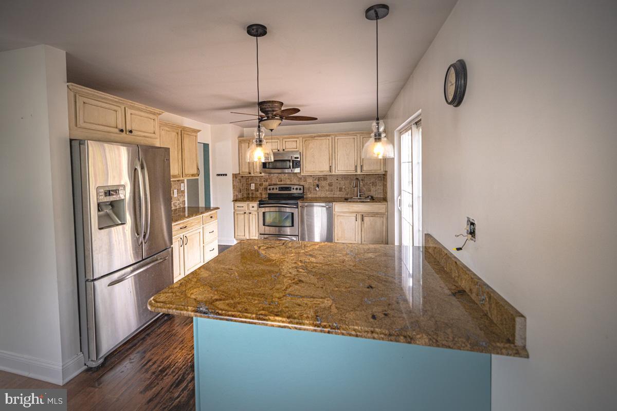 892 Estates Boulevard Hamilton, NJ 08690 - Photo 8 of 36 a kitchen with stainless steel appliances granite countertop a sink and refrigerator