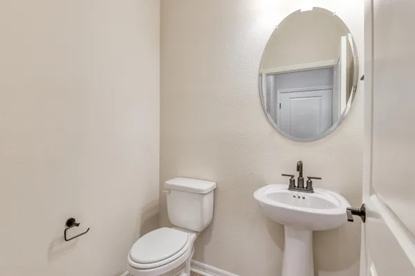 a bathroom with a toilet a sink and mirror