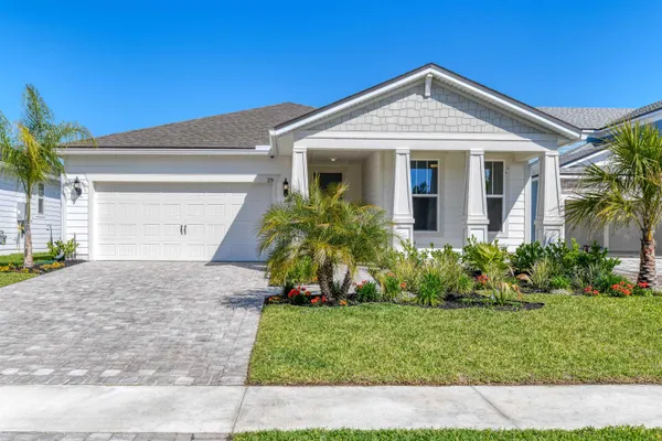 a front view of a house with a garden and plants