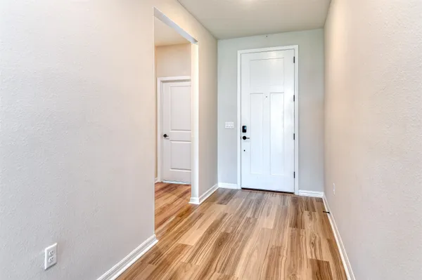 a view of a room with wooden floor and a bathroom