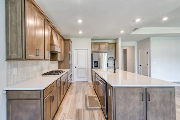 a large kitchen with stainless steel appliances granite countertop a lot of counter space and wooden floors